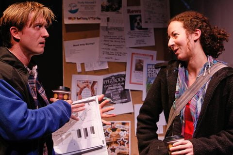 Two characters talk at a department bulletin board